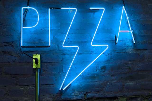 Neon sign displaying the name Pizza